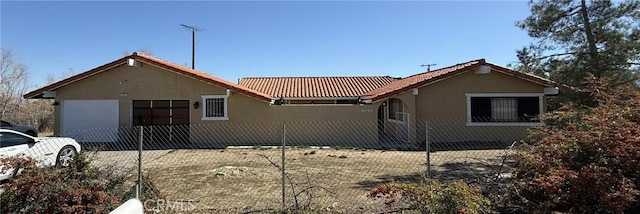 view of front of home with concrete driveway, an attached garage, a tile roof, and stucco siding