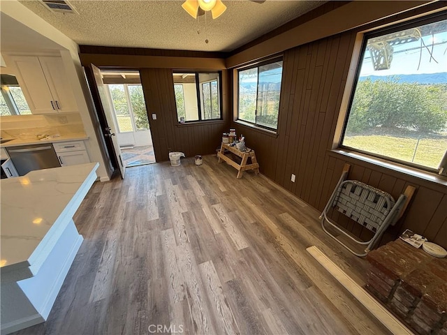 unfurnished sunroom with a ceiling fan and visible vents