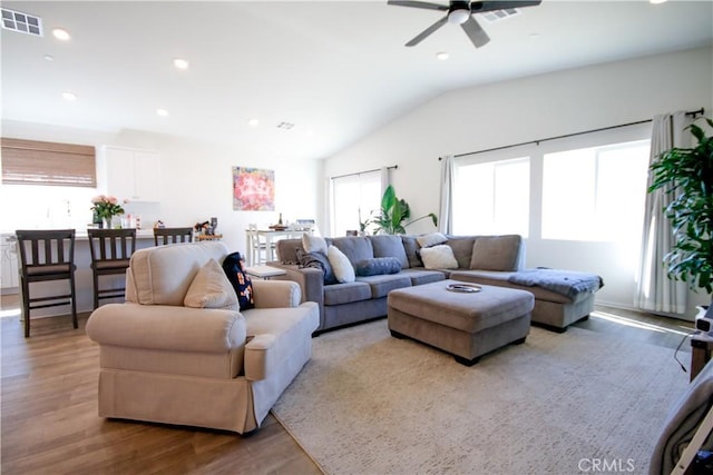 living room with wood-type flooring, ceiling fan, and lofted ceiling