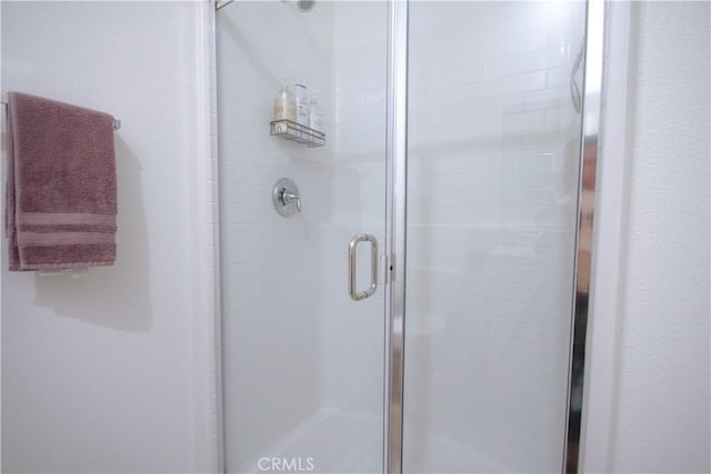 bathroom featuring a shower with door