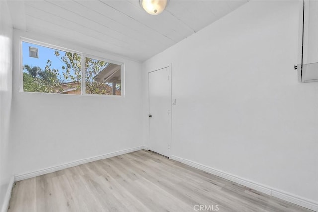 unfurnished room with vaulted ceiling and light hardwood / wood-style flooring