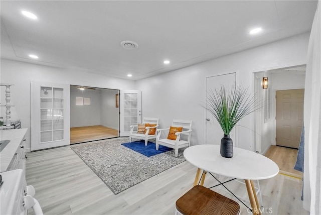 living area with light wood-type flooring and french doors