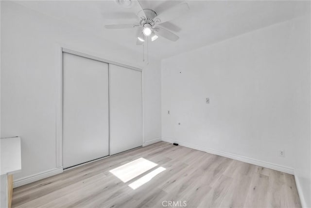 unfurnished bedroom featuring light hardwood / wood-style floors, a closet, and ceiling fan