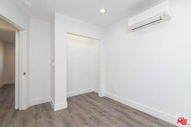 interior space featuring wood-type flooring and an AC wall unit