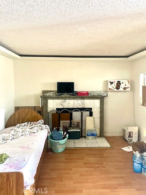 bedroom featuring a textured ceiling and light hardwood / wood-style flooring