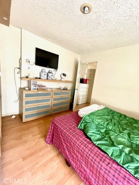 bedroom with wood-type flooring and a textured ceiling