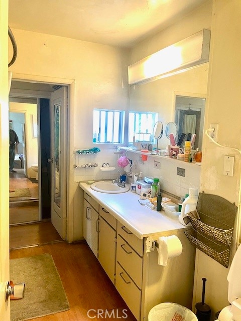 bathroom featuring vanity, decorative backsplash, and hardwood / wood-style flooring