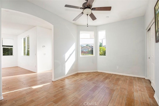 spare room with ceiling fan, plenty of natural light, and light hardwood / wood-style flooring