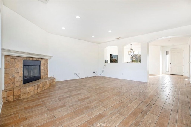 unfurnished living room with light hardwood / wood-style floors and a tiled fireplace