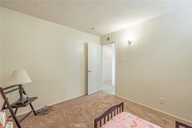 bedroom featuring a textured ceiling and light carpet