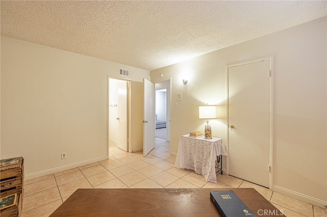 interior space with light tile patterned floors and a textured ceiling