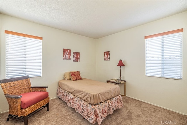 bedroom featuring light colored carpet and a textured ceiling