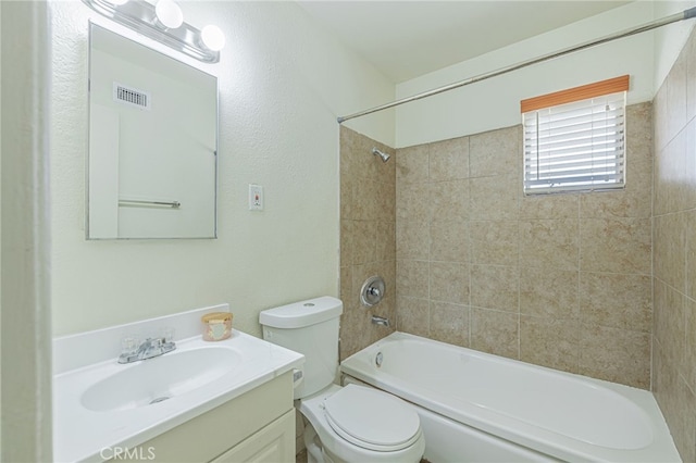 full bathroom with vanity, tiled shower / bath combo, and toilet