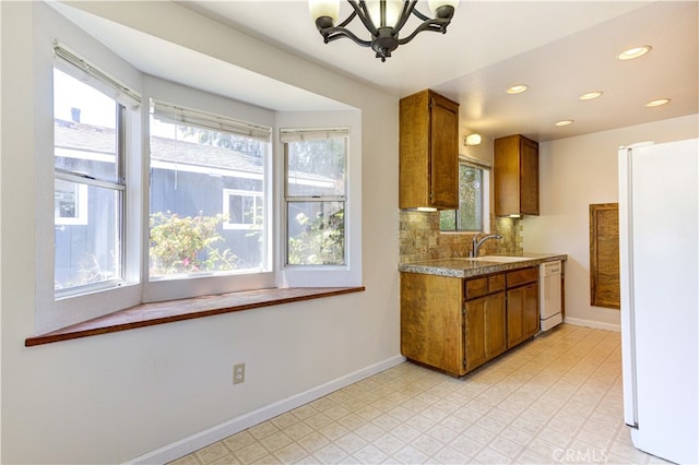 kitchen with tasteful backsplash, a chandelier, plenty of natural light, and white appliances