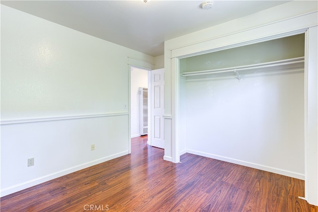 unfurnished bedroom featuring a closet and dark hardwood / wood-style floors