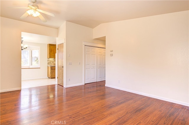 spare room featuring hardwood / wood-style floors and ceiling fan with notable chandelier