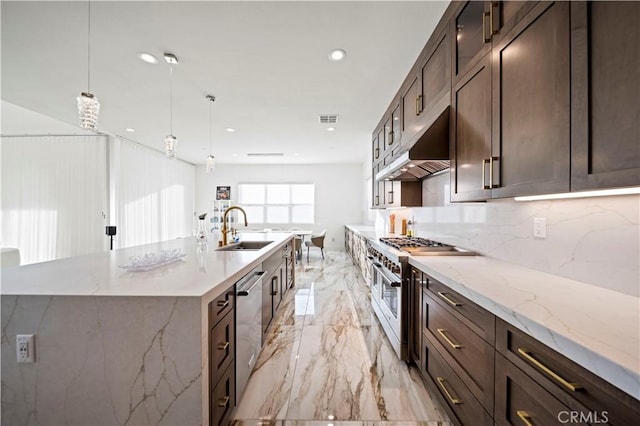 kitchen with decorative light fixtures, sink, light stone counters, and stainless steel appliances