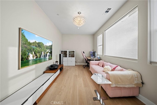 interior space with plenty of natural light, light wood-type flooring, and an inviting chandelier