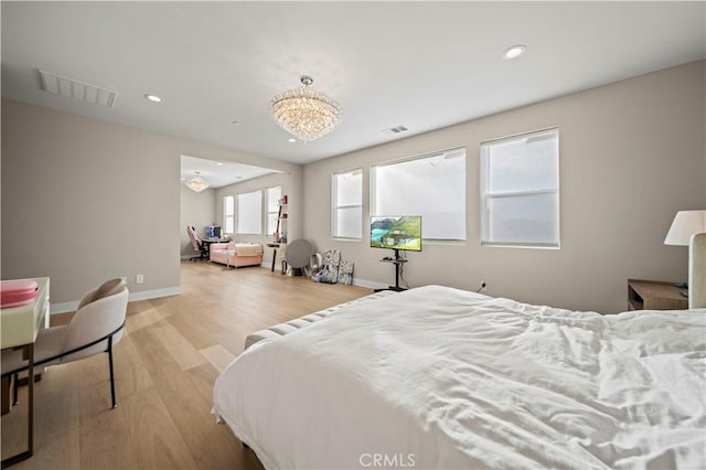 bedroom featuring a notable chandelier and light wood-type flooring