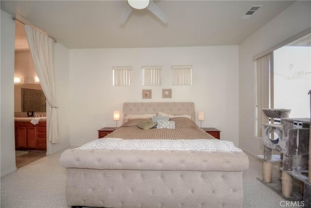 carpeted bedroom featuring ceiling fan and ensuite bath