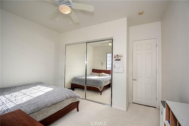 carpeted bedroom featuring ceiling fan and a closet