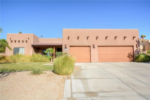 pueblo-style house featuring a garage