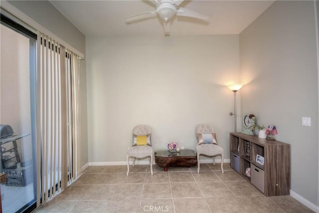 living area with ceiling fan and light tile patterned floors