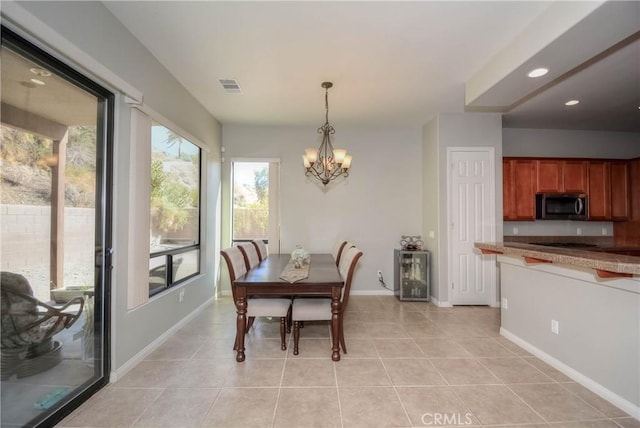 dining room with light tile patterned flooring and a chandelier