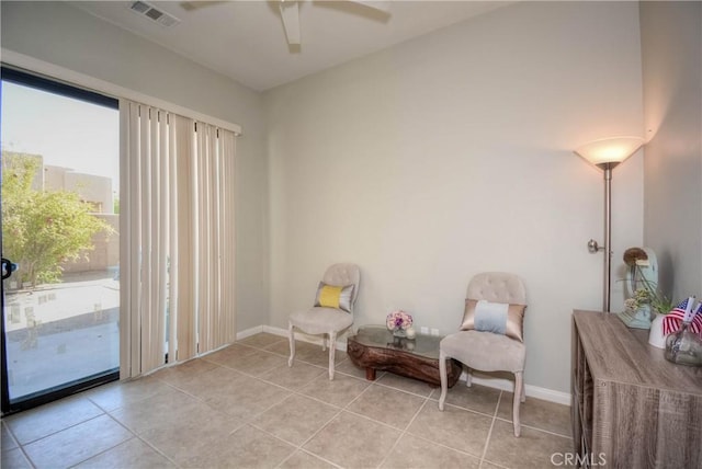 sitting room featuring ceiling fan, light tile patterned flooring, and a wealth of natural light