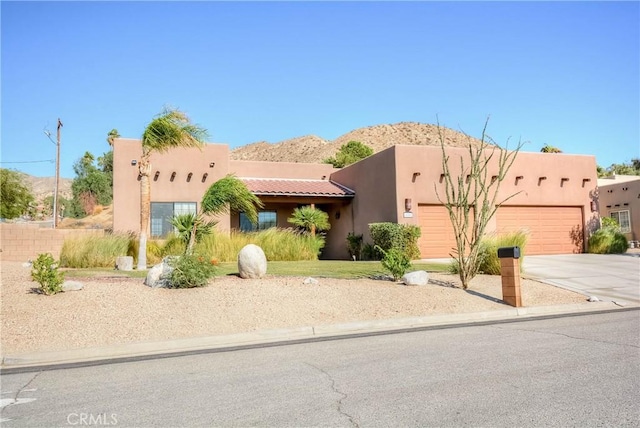 pueblo-style home featuring a mountain view and a garage