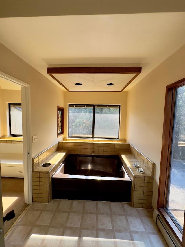 bathroom with tiled bath, a wealth of natural light, and a baseboard radiator