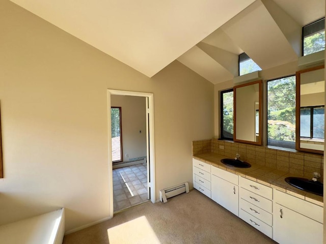 bathroom with decorative backsplash, a baseboard radiator, vanity, and lofted ceiling