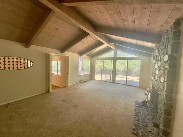 unfurnished living room with wooden ceiling, vaulted ceiling with beams, a stone fireplace, and carpet floors