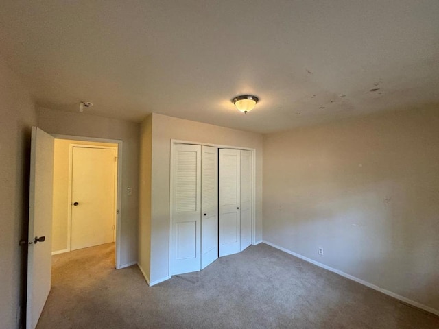 unfurnished bedroom featuring a closet and carpet flooring