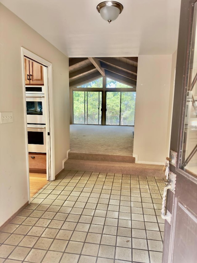 hallway with light carpet and vaulted ceiling