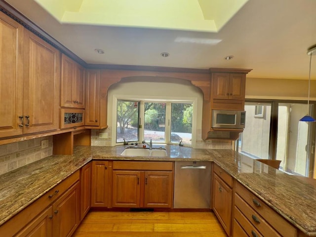 kitchen featuring light stone countertops, sink, pendant lighting, and kitchen peninsula