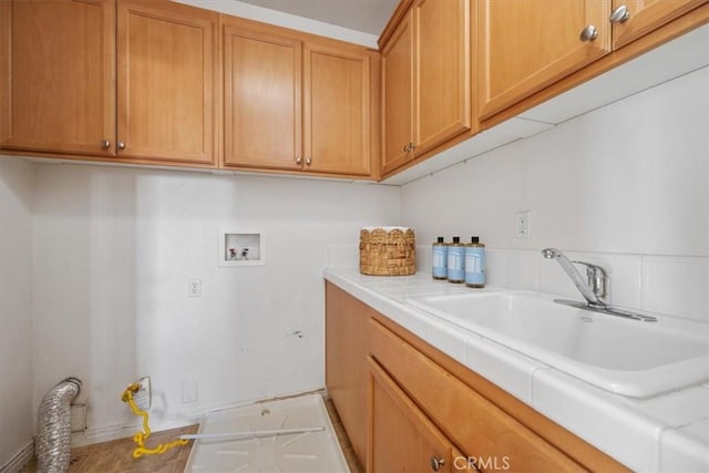 clothes washing area with cabinets, hookup for a washing machine, and sink