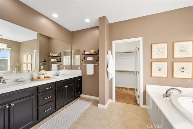 bathroom featuring tile patterned floors, vanity, and a relaxing tiled tub