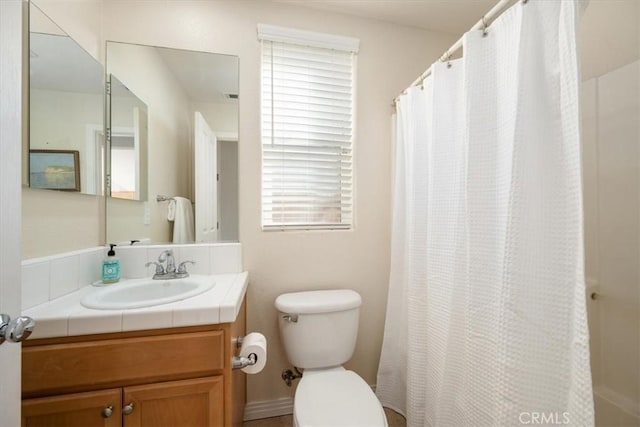 bathroom with vanity, toilet, and a wealth of natural light