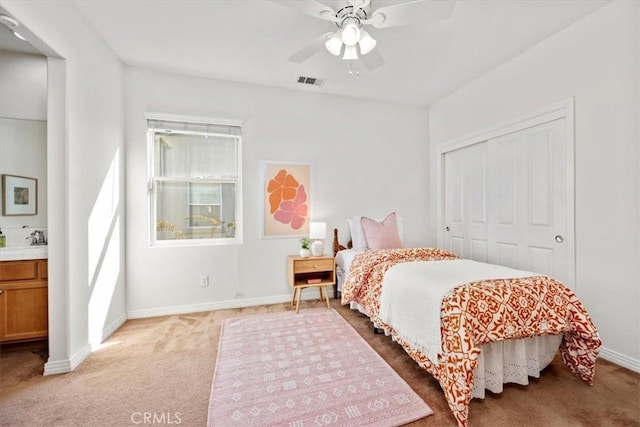 bedroom featuring carpet, ceiling fan, sink, and a closet