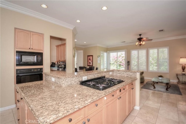 kitchen featuring light stone countertops, ceiling fan, light brown cabinetry, a kitchen island, and black appliances