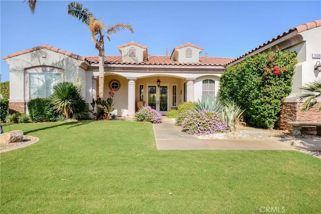 mediterranean / spanish house featuring french doors and a front lawn