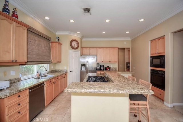 kitchen featuring a center island, light brown cabinets, sink, a breakfast bar area, and black appliances