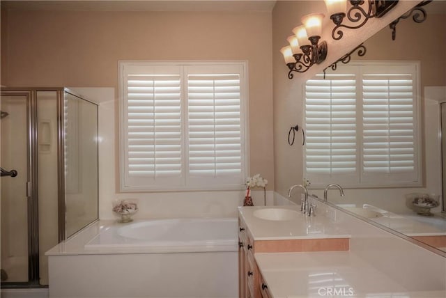 bathroom with plus walk in shower, vanity, and a healthy amount of sunlight