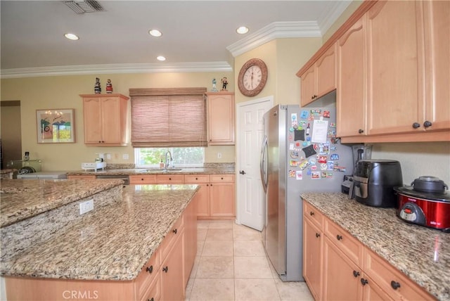 kitchen with light stone countertops, light brown cabinetry, ornamental molding, and sink