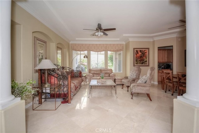 sitting room with decorative columns, ceiling fan, and crown molding