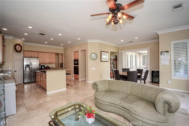 living room with ceiling fan, light tile patterned floors, ornamental molding, and a wealth of natural light