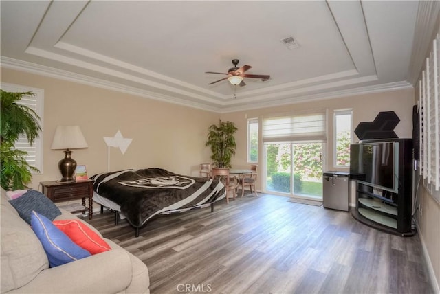 bedroom with hardwood / wood-style flooring, ceiling fan, a raised ceiling, and access to outside