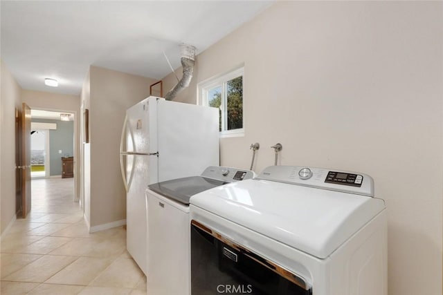 clothes washing area with washing machine and dryer and light tile patterned floors