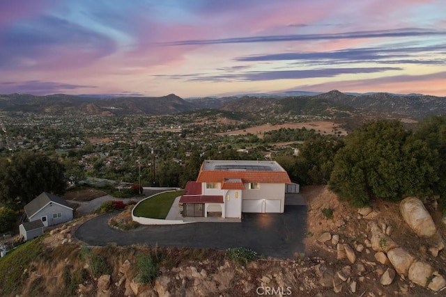 aerial view at dusk featuring a mountain view